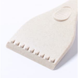 A beige ice scraper with a textured edge, featuring a curved handle and a smooth surface. It has a logo on it.