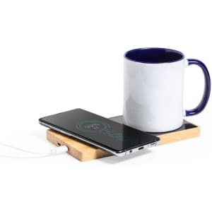 A wooden charger cup warmer with a white mug and a smartphone, featuring a charging indicator on the phone's screen.