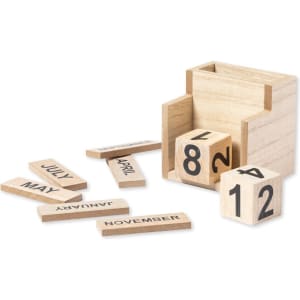 A wooden pencil holder in light colour containing removable blocks with numbers and month names scattered around it.