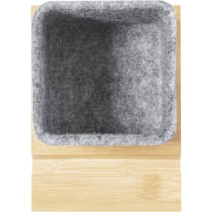 A grey felt pencil holder sits atop a light bamboo base. The container is square-shaped and empty.