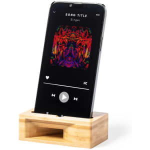 A bamboo phone stand holds a smartphone displaying a colourful music player interface. It features a branding logo.
