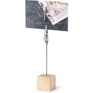 A metal clip attached to a wooden base holds up a piece of card, suitable for office use.