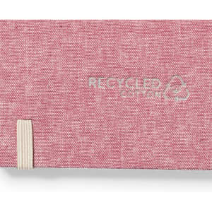 A pink notepad with a textured finish and an elastic band, made from recycled cotton, featuring a branding logo.