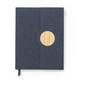A dark blue notepad with a round wooden accent and a ribbon bookmark. It has a subtle texture and a branding logo.
