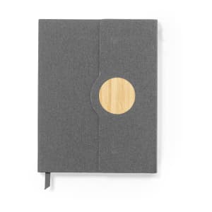 A grey notepad with a circular bamboo accent on the cover, featuring a bookmark ribbon.