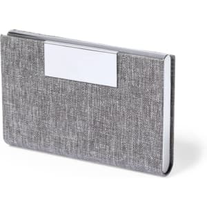 A grey fabric business card holder with a silver-coloured logo plate on the front.