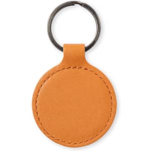 An orange round keyring with a metal loop, featuring a smooth surface and stitched edges.