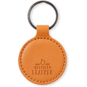 A round keyring made of orange recycled leather, featuring a metal keyring attachment and a small logo.
