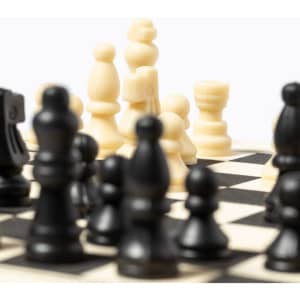 A chessboard featuring black and cream pieces in strategic positions, highlighting the game's competitive nature.