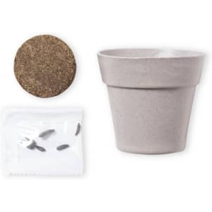 A grey flowerpot with a coir disc and a packet of seeds, all arranged together. The pot has a simple design.