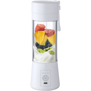 A white portable blender with mixed fruit inside, featuring a transparent body and a power button on the base.