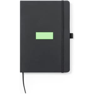 A black notepad with a green label, featuring a logo and an elastic band closure.