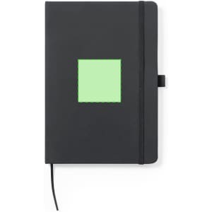 A black notepad with a green square design on the cover, featuring an elastic closure and bookmark ribbon.