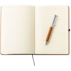 A brown notebook with lined pages, opened, featuring a silver and wood pen resting on top.