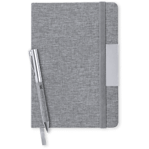 A grey notebook with an elastic band and a matching pen beside it. The notebook has a branding logo.