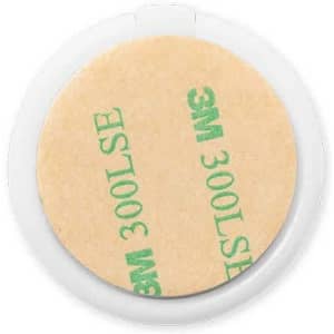 A circular adhesive disc with a tan backing, featuring a 3M logo, enclosed in a clear plastic case.