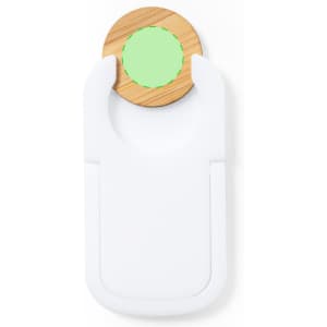 A white phone stand with a circular wooden accent featuring a green centre, designed for holding devices.