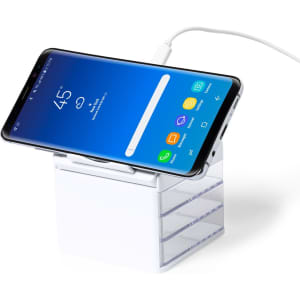 A white phone charger organiser with a smartphone resting on top, connected to a charging cable.