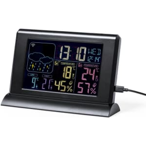 A weather station in black displaying time, temperature, humidity, and weather icons with a charging port.