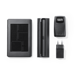 A black weather station kit featuring a main unit, sensor, and power adapter. Includes a logo on the main unit.