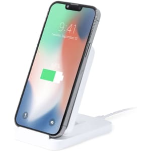 A white wireless charger with a smartphone propped up, displaying a battery charging icon.