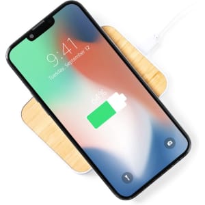 A wireless charger with a wooden base and a smartphone displaying a battery charging icon.