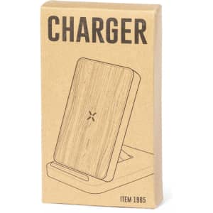 A wireless charger in a minimalist design with a wooden finish, presented in a simple cardboard box featuring a logo.