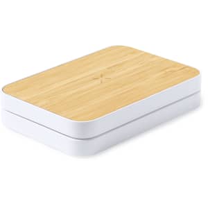 A wireless charger with a bamboo top and a white base, featuring a smooth, rounded rectangular design and a logo.