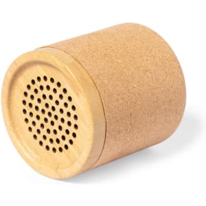 A cylindrical speaker with a cork exterior and a wooden top featuring small holes for sound projection.