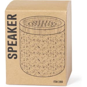 A compact speaker in a kraft box with a wood and cork design. The box features a logo and clear speaker holes on top.