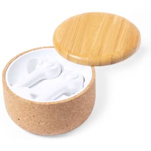 A pair of white earphones housed in a round cork and bamboo case.
