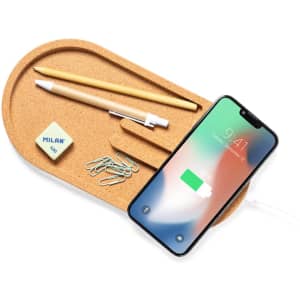 A cork wireless charger with a phone, pencil, eraser, paperclips, and a pen holder, all in neutral tones.