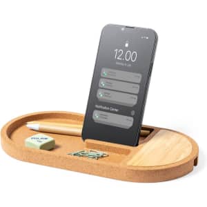 A cork organiser with a phone stand, a pencil, an eraser, and paperclips in a natural wood finish.