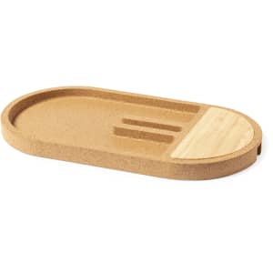 An oval, cork organiser with a wooden section, featuring grooves for holding devices and accessories.