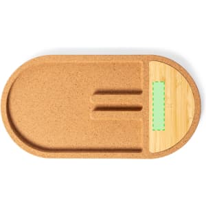 An oval charger in natural cork with a bamboo section, featuring grooves for organising devices.