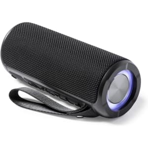 A black portable speaker with a fabric texture, featuring a circular control button and a carrying strap.