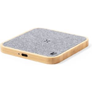 A wireless charger with a grey fabric surface and a bamboo wood base, featuring a logo on the side.