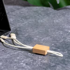 A charging cable with a wooden connector, featuring a natural colour scheme and textured white cord.