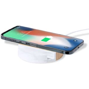 A wireless charger in white and bamboo, with a smartphone displaying a charging status on top.