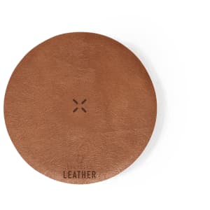 A round brown leather coaster with a minimalist design and a small logo at the bottom.