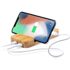 A bamboo power bank with a smartphone charging, featuring multiple USB ports and a sleek design.