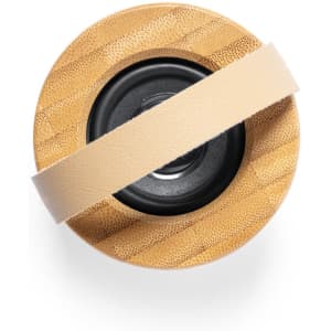 A round Durbal Speaker featuring a bamboo exterior and a central black speaker area, secured with a beige strap.