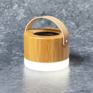 A bamboo speaker with a light-up base and a leather handle, featuring a natural wood finish.