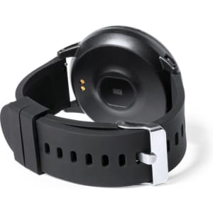 A black smart watch with a silicone strap and a silver buckle, showcasing the back view with charging contacts.