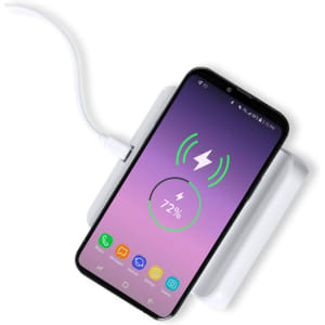 A multifunction alarm clock in white with a smartphone charging wirelessly on top, displaying a charging icon.