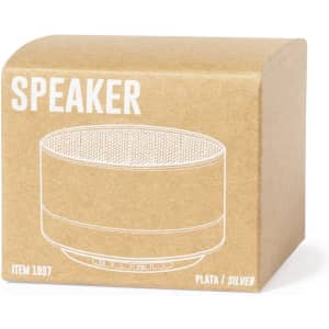 A silver speaker packaged in a kraft box, featuring a mesh top and control buttons on the front, along with a logo.