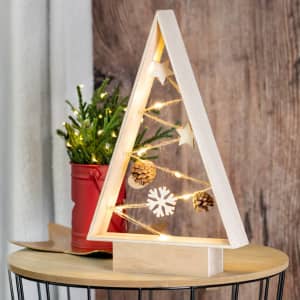 A decorative wooden Christmas tree with soft white lights, ornaments, and a small potted plant in a red pot.
