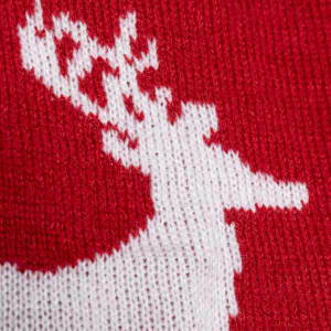 A red scarf featuring a white reindeer design, made from knitted fabric. It includes a logo.