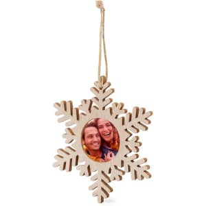 A wooden snowflake-shaped Christmas decoration featuring a circular photo cutout in the centre, with a hanging string.