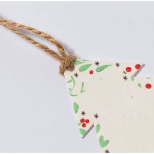 A decorative tag shaped like a Christmas tree, featuring green and red patterns, with a twine attachment.